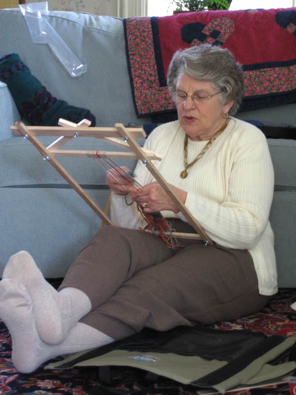 Weaver focused on weaving on lap loom